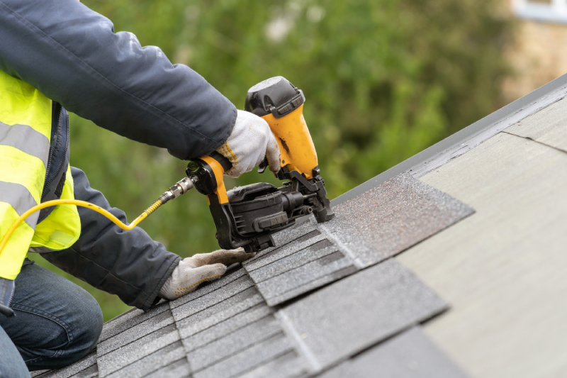Laborer Installing Roof Shingles with Nail Gun | Rolox Home Service LLC
