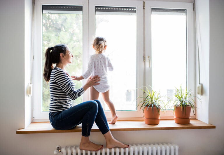 Window glass types; women and child sitting in front of three pane window | Rolox Home Service LLC.