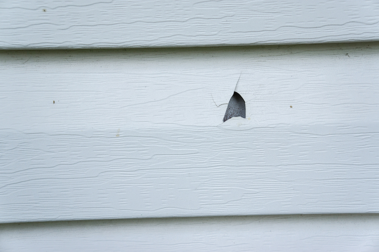 Hail damage hole to vinyl siding | Rolox Home Service LLC