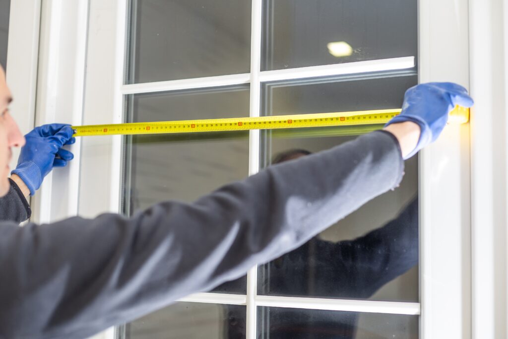 Man measuring a custom window for a home renovation
