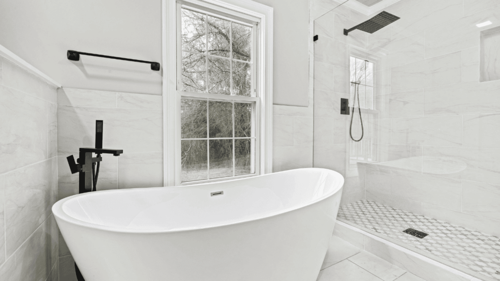 bathroom walk in shower with glass doors and large and deep white tub