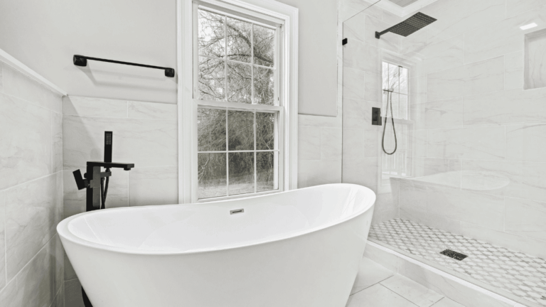 bathroom walk in shower with glass doors and large and deep white tub