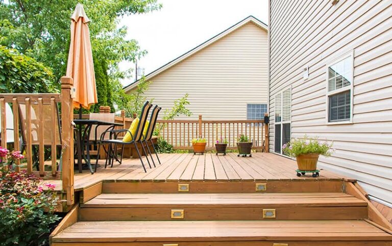 deck with three steps, patio furniture, and plants in pots